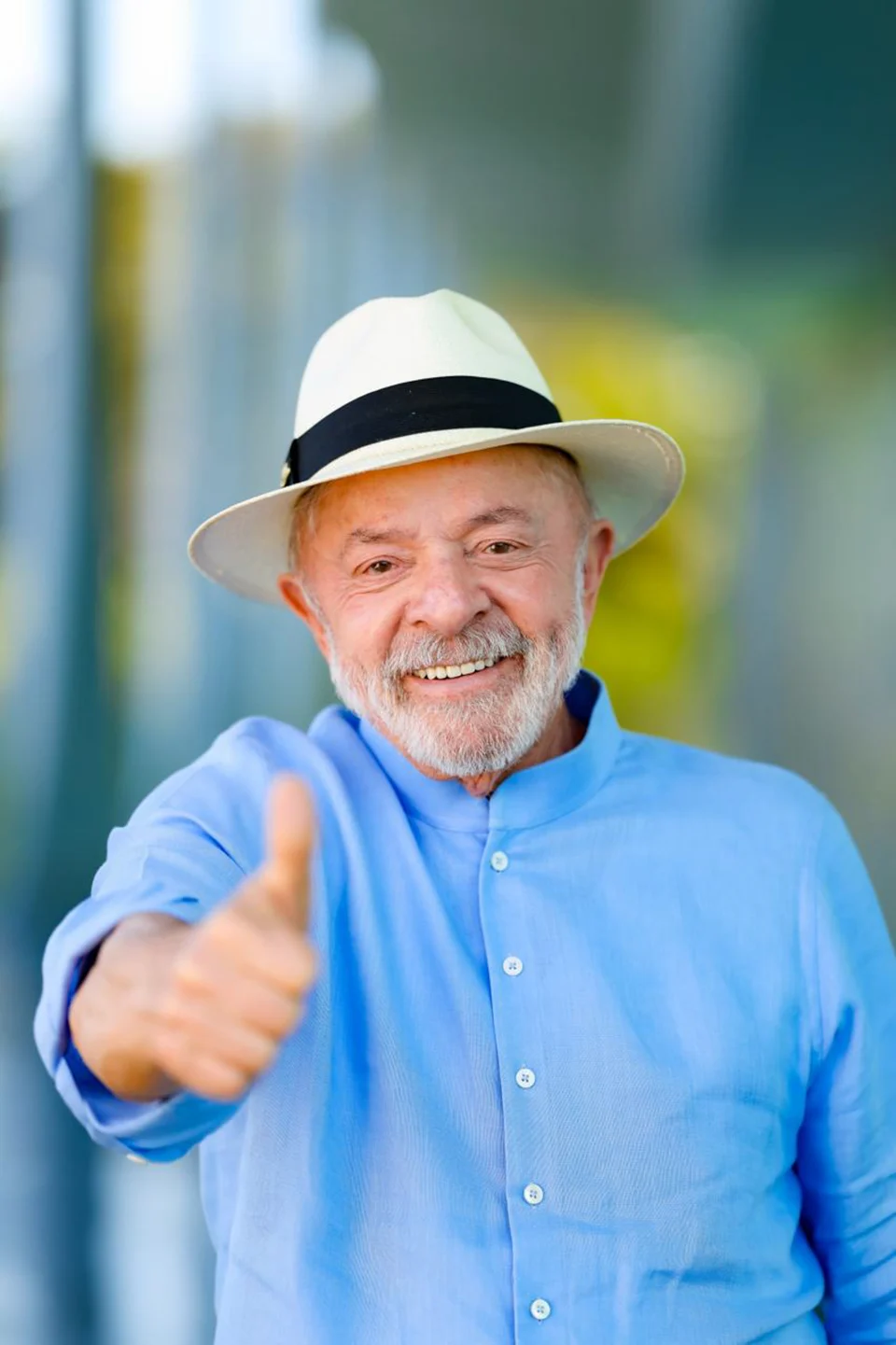 Lula de camisa azul e chapéu, com uma das mãos estendida, no Palácio da Alvorada.